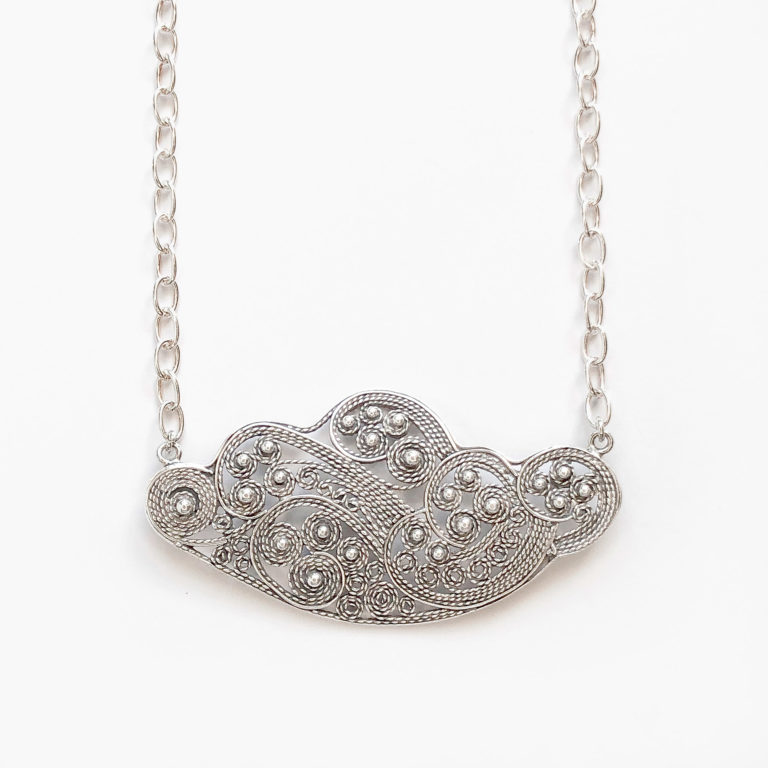 Collar formado por un colgante en forma de nube de filigrana con espirales, volutas y bolas ornamentales que se engasta a una cadena de eslabones