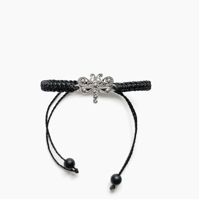Vista frontal de pulsera de ganchillo en color negro rematada con tiradores y una pequeña damisela central con elegante diseño de filigrana y bolitas